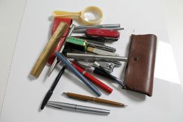 A box of assorted pens, pocket knives, magnifying glass,