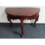 A reproduction mahogany demi-lune table