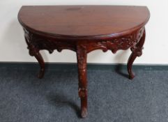 A reproduction mahogany demi-lune table