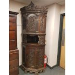 A heavily carved beech corner cabinet, width 90 cm.