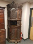 A heavily carved beech corner cabinet, width 90 cm.