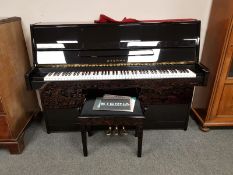 An Eterna by Yamaha ebonised upright overstrung piano model ER-C10, serial number C 20011,