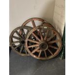 Three antique cart wheels