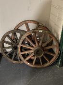 Three antique cart wheels