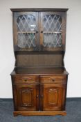 An oak dresser with leaded glass doors