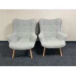 A pair of contemporary armchairs in grey button fabric