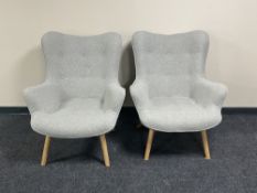 A pair of contemporary armchairs in grey button fabric