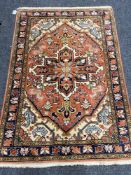 A fringed Iranian rug on pink ground