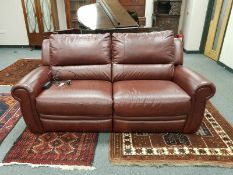 A good quality burgundy leather electric reclining two seater settee, width 195 cm.