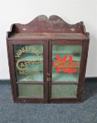 An Edwardian pine glazed door wall cabinet bearing advertising