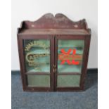 An Edwardian pine glazed door wall cabinet bearing advertising