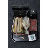 A tray of cased binoculars, tea card albums and cards, hair clippers, Brownie camera,