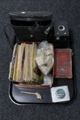 A tray of cased binoculars, tea card albums and cards, hair clippers, Brownie camera,