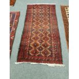 An Afghan rug on red ground,