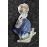 A Lladro figure of a girl with basket of flowers