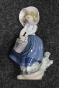 A Lladro figure of a girl with basket of flowers