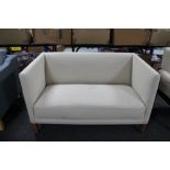 A 20th century Danish two seater settee in oatmeal fabric