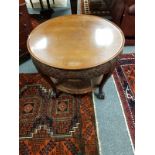 A heavily carved circular mahogany coffee table with bergere undershelf, diameter 78 cm.