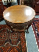 A heavily carved circular mahogany coffee table with bergere undershelf, diameter 78 cm.