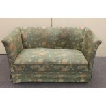 A 1930's two seater settee in green floral fabric