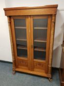 A continental mahogany glazed bookcase on paw feet,