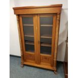 A continental mahogany glazed bookcase on paw feet,