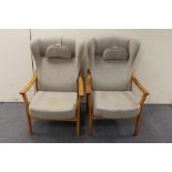 A pair of teak framed armchairs in grey fabric