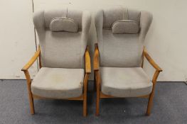 A pair of teak framed armchairs in grey fabric