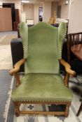 A 20th century oak wingback armchair in green dralon