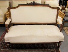 An antique mahogany framed settee in cream fabric