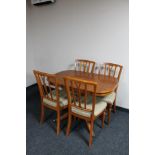 An inlaid yew wood extending dining table and four chairs