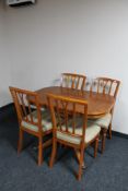 An inlaid yew wood extending dining table and four chairs