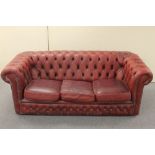 A red buttoned leather three seater Chesterfield settee