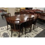 A mahogany extending dining table with two leaves and six rail back chairs