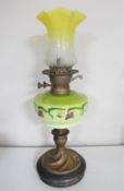 A Victorian oil lamp with hand painted glass reservoir and two tone glass shade