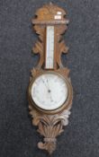 An Edwardian carved oak cased barometer by R Rosmond of Leicester