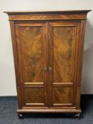 An antique continental walnut double door cabinet