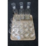 A tray of three etched glass decanters with labels,