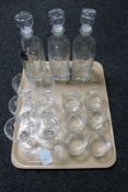A tray of three etched glass decanters with labels,