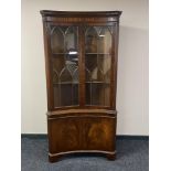 A reproduction mahogany concave corner display cabinet (locked,