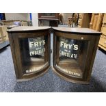 A pair of early 20th century oak glazed door corner cabinets bearing Fry's Chocolate advertising