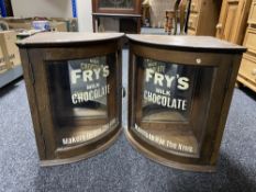 A pair of early 20th century oak glazed door corner cabinets bearing Fry's Chocolate advertising