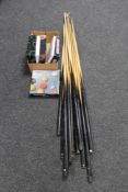 A box of ten assorted pool cues with rests,