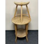 An early 20th century two tier occasional table and a milking stool