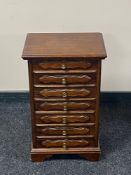 A stained beech wood seven drawer miniature chest