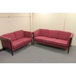 Two Danish wooden framed settees in maroon fabric