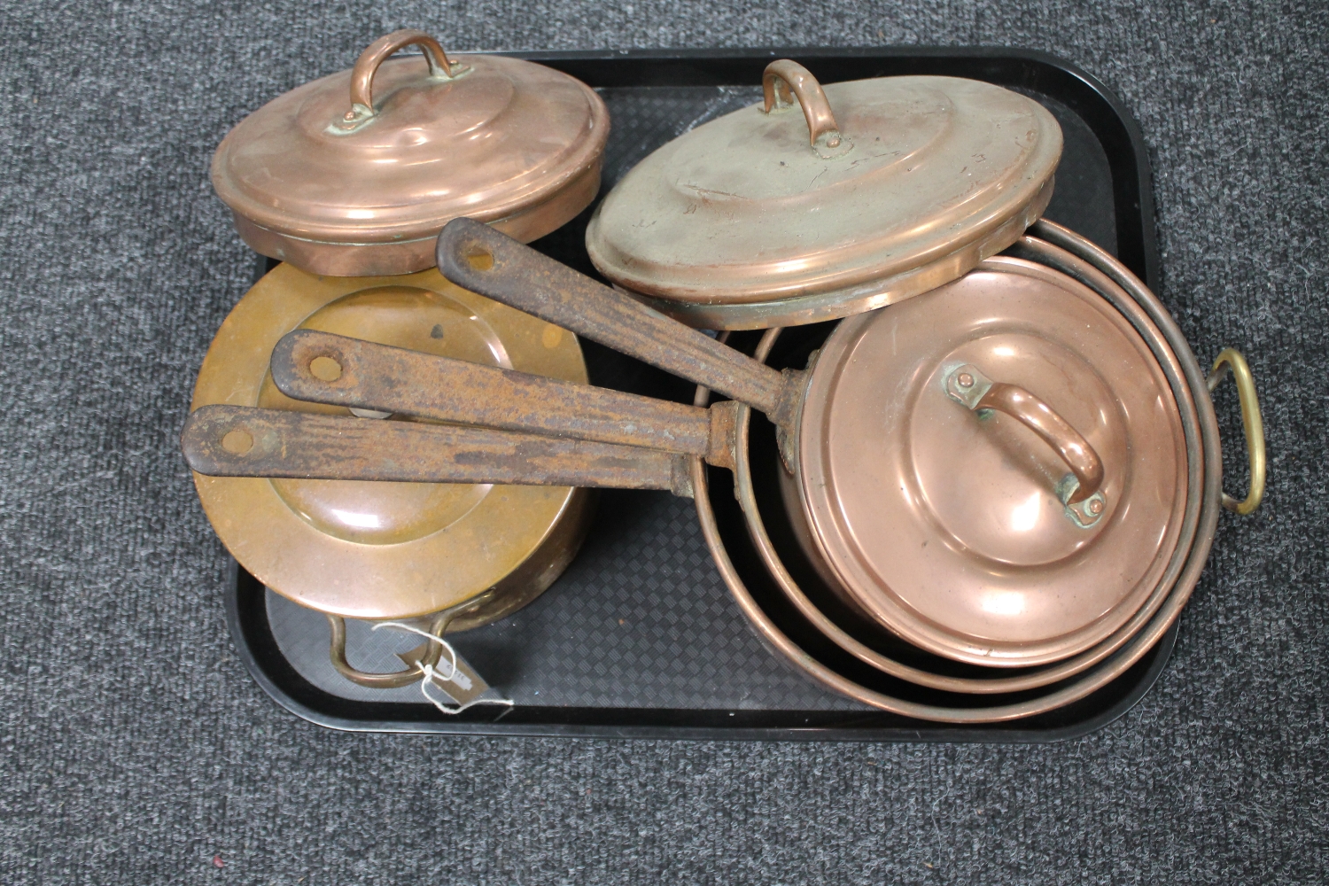 A tray of three antique copper cast iron handled pans with lids and an antique cooking pot