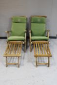 A pair of teak steamer armchairs with foot rests and cushions