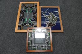 A framed leaded glass window of a galleon and two further windows