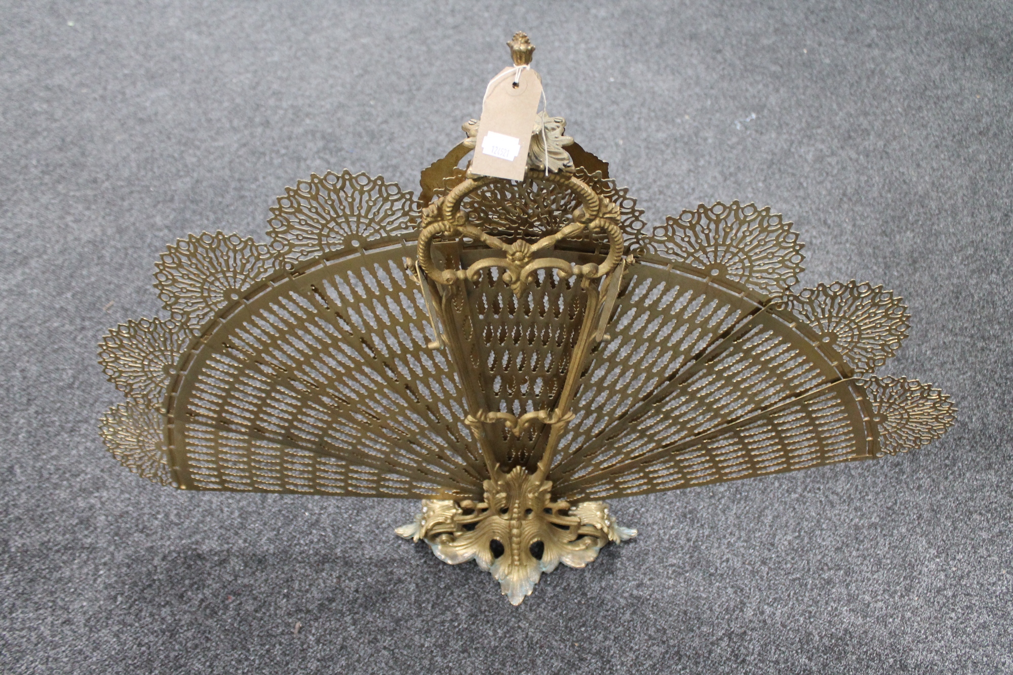 A decorative brass peacock fire screen